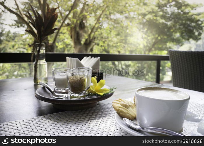 Hot coffee latte on balcony wooden table, stock photo