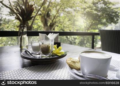 Hot coffee latte on balcony wooden table, stock photo