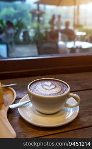 Hot coffee latte with latte art milk foam in cup mug on wood desk on top view. As breakfast In a coffee shop at the cafe,during business work concept