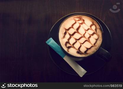Hot coffee on wooden saucer on wooden table