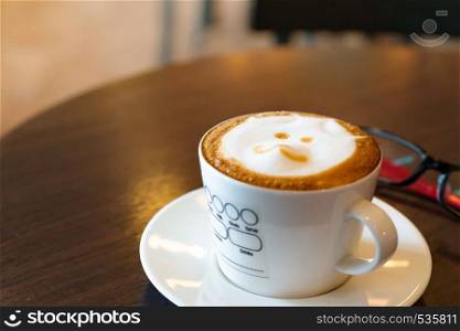 hot coffee on wooden table with eye glasses