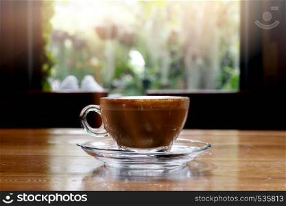 hot coffee on wooden table with morning nice view on window