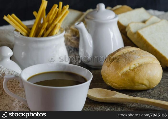 hot coffee with fresh bread on wooden table , still life