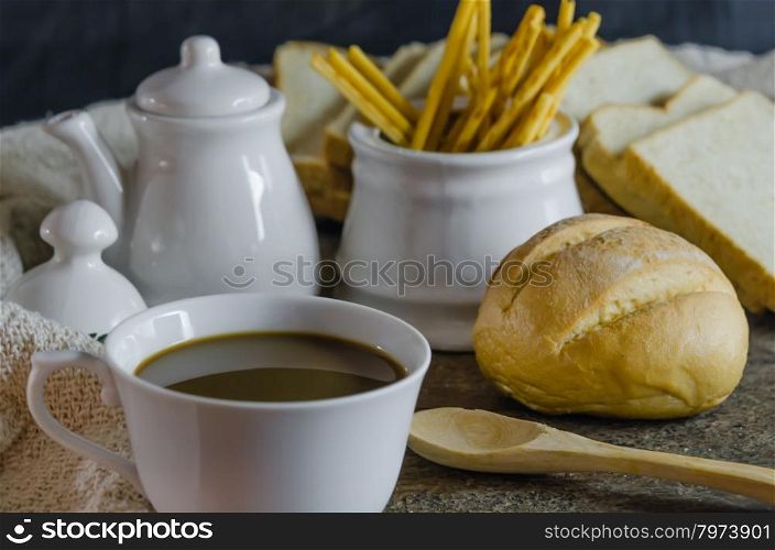 hot coffee with fresh bread on wooden table , still life