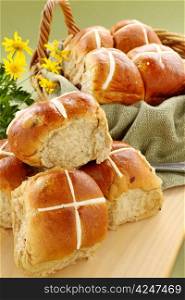 Hot cross buns in a basket with daisies ready to serve.