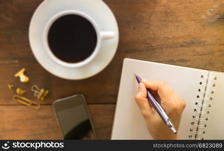 Hot cup of coffee on wooden work table, stock photo