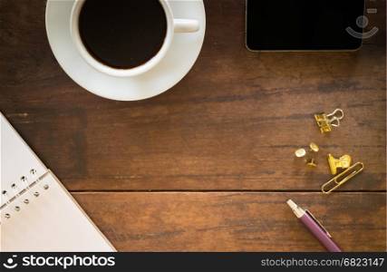 Hot cup of coffee on wooden work table, stock photo