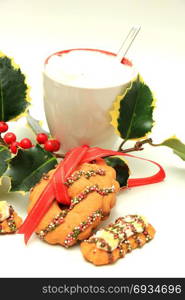 Hot drink and christmas cookies decorated with chocolate and sprinkles