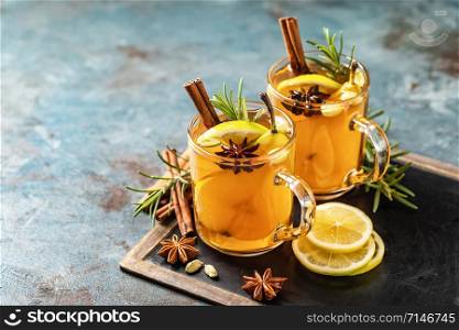 Hot drink cocktail for New Year, Christmas, winter or autumn holidays.Toddy. Mulled pear cider or spiced tea or grog with lemon, pear, cinnamon, anise, cardamom, rosemary.