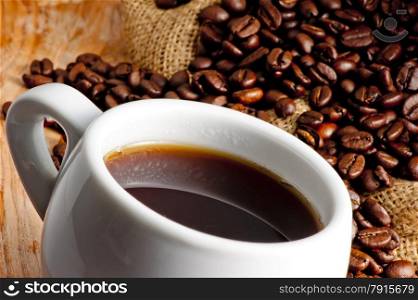 hot drink in a cup and roasted coffee beans