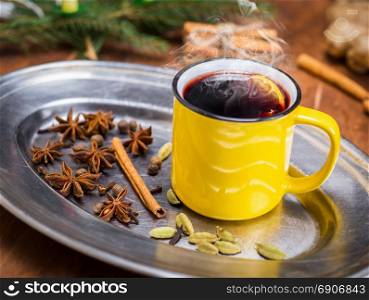hot drink mulled wine in a yellow mug and dried star anise