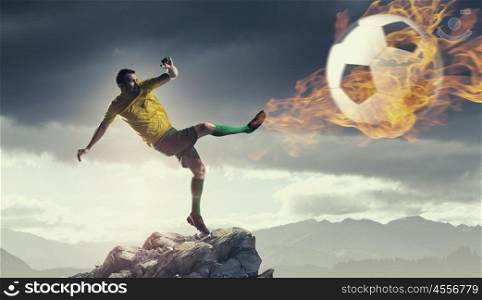 Hot football player. Shoot of football player on the top of rock