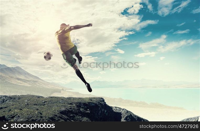 Hot football player. Shoot of football player on the top of rock