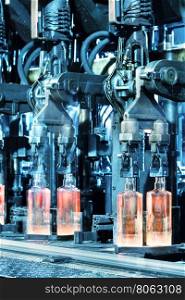Hot glass bottles on conveyor belt plant. Hot glass bottles