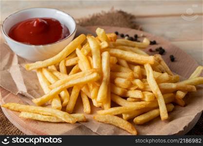 Hot golden french fries with sauce on a wooden background. Homemade rustic food.. Hot golden french fries with sauce on wooden background. Homemade rustic food.