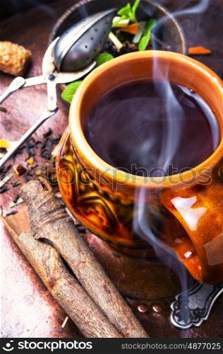 Hot herbal tea. Clay cup with herbal tea on a vintage background
