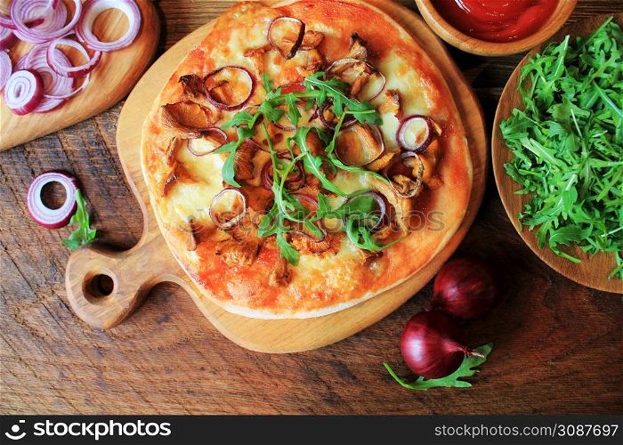 Hot homemade pizza with mushrooms chanterelle, rucola on wooden table. Top view .. Hot homemade pizza with mushrooms chanterelle, rucola on wooden table. Top view