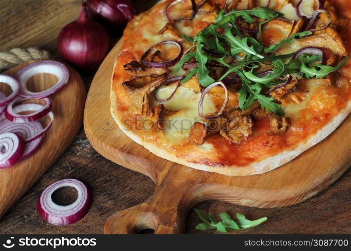 Hot homemade pizza with mushrooms chanterelle, rucola on wooden table. Top view .. Hot homemade pizza with mushrooms chanterelle, rucola on wooden table. Top view