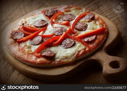 Hot homemade pizza with Pepperoni, paprica on wooden table. Top view .. Hot homemade pizza with Pepperoni, paprica on wooden table. Top view