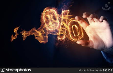 Hot interest rate. Hand touch percent light glowing symbol on dark background