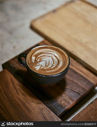 Hot latte art coffee on wooden table,focus at white foam. . Hot latte art coffee on wooden table