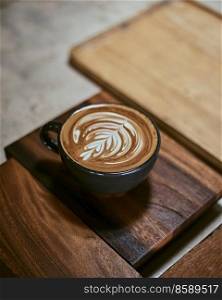 Hot latte art coffee on wooden table,focus at white foam. . Hot latte art coffee on wooden table