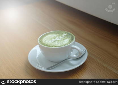 hot matcha green tea latte on wood table. delicious beverage