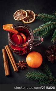 Hot mulled wine in glass cup on a dark background. Warm Christmas drink with spices and fruits.. Hot mulled wine in glass cup on dark background. Warm Christmas drink with spices and fruits.