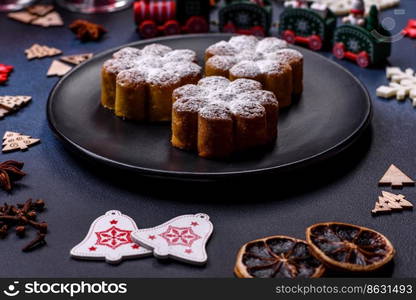 Hot mulled wine with a slice of orange, with cinnamon, cloves and other spices with chocolate muffins and Christmas decorations on a dark concrete background. Hot mulled wine with a slice of orange, with cinnamon, cloves and other spices