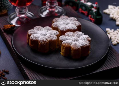 Hot mulled wine with a slice of orange, with cinnamon, cloves and other spices with chocolate muffins and Christmas decorations on a dark concrete background. Hot mulled wine with a slice of orange, with cinnamon, cloves and other spices