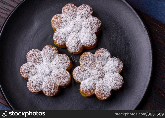 Hot mulled wine with a slice of orange, with cinnamon, cloves and other spices with chocolate muffins and Christmas decorations on a dark concrete background. Hot mulled wine with a slice of orange, with cinnamon, cloves and other spices