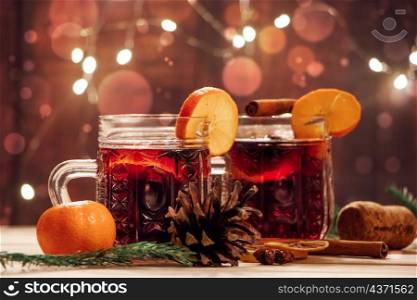 Hot mulled wine with fruits and spices on a wooden background. Winter warming holiday drink.. Hot mulled wine with fruits and spices on wooden background. Winter warming holiday drink.