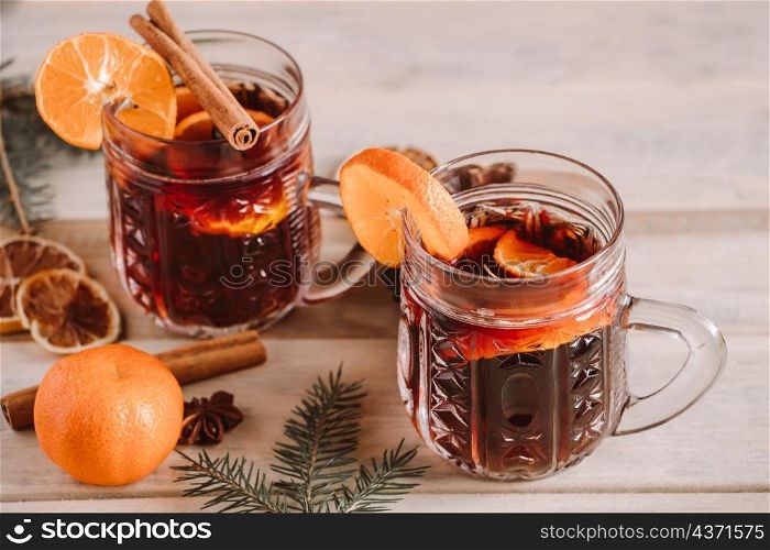 Hot mulled wine with spices in glass cup on a wooden background. Christmas warming drink.. Hot mulled wine with spices in glass cup on wooden background. Christmas warming drink.