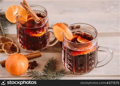 Hot mulled wine with spices in glass cup on a wooden background. Christmas warming drink.. Hot mulled wine with spices in glass cup on wooden background. Christmas warming drink.