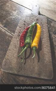 Hot peppers on wooden kitchen cutting board