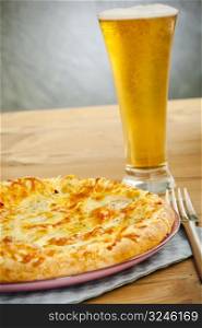 Hot pizza on the plate with cold beer