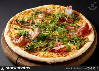 Hot pizza Prosciutto on a rustic wooden table. Italian food.