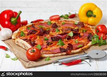 Hot pizza with ingredients on wooden table
