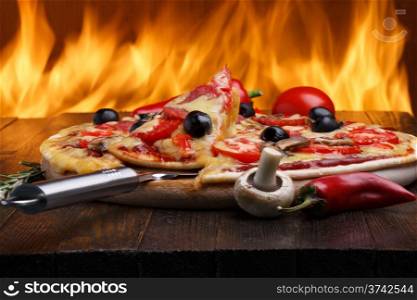 Hot pizza with oven fire on background