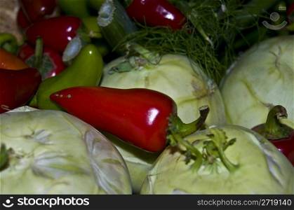hot red and green peppers lying on top of some kohlrabi
