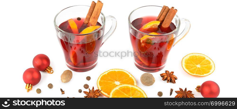 Hot red mulled wine isolated on white background with spices, orange slice, anise and cinnamon sticks, close up. Flat lay, top view. Wide photo.