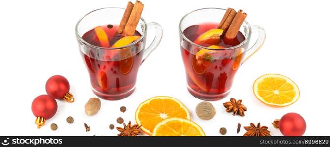 Hot red mulled wine isolated on white background with spices, orange slice, anise and cinnamon sticks, close up. Flat lay, top view. Wide photo.