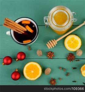 Hot red mulled wine on wooden background with spices, orange slice, anise and cinnamon sticks, close up. Flat lay, top view.