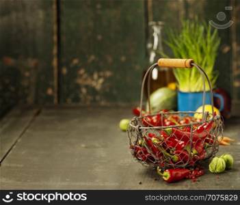 Hot red pepper and ingredients for cooking on rustic background