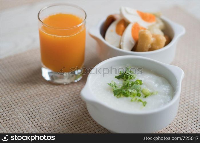 Hot rice mush set with orange juice for breakfast