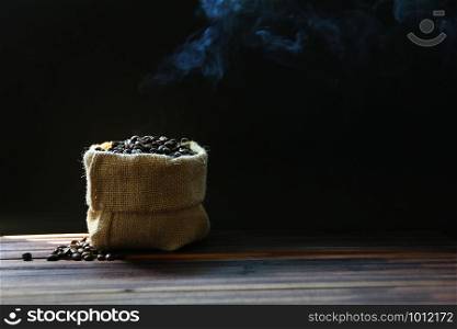 hot roasted coffee beans in sack isolate on black background