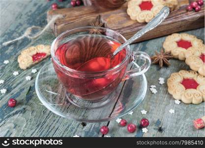 Hot tea in a transparent cup, jam and cookies
