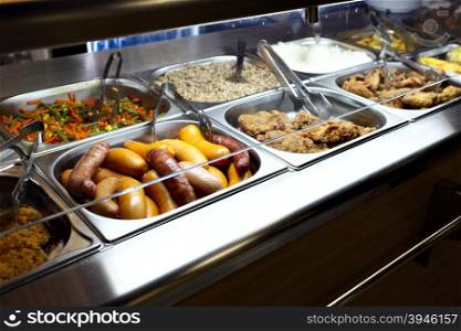 Hot trays with cooked food in dining room