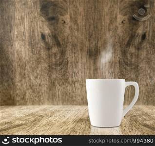 Hot White coffee cup on wood floor and blur wood room,Leave space for adding content.