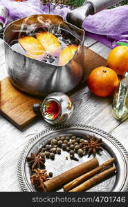 Hot wine with oranges. Warmed red wine in retro scoop with spices